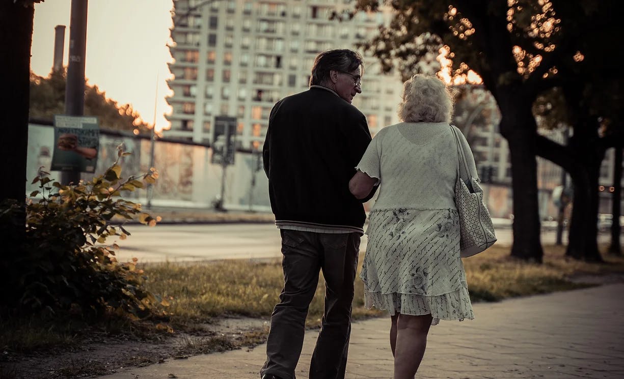 elderly couple walking down the street